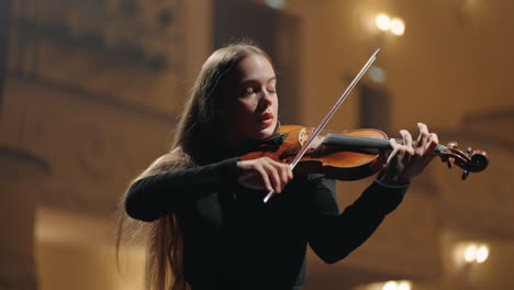 Concierto-De-Música-Clásica-En-La-Sala-Filarmónica-Una-Joven-Violinista-Toca-El-Violín-En-La-Oscuridad