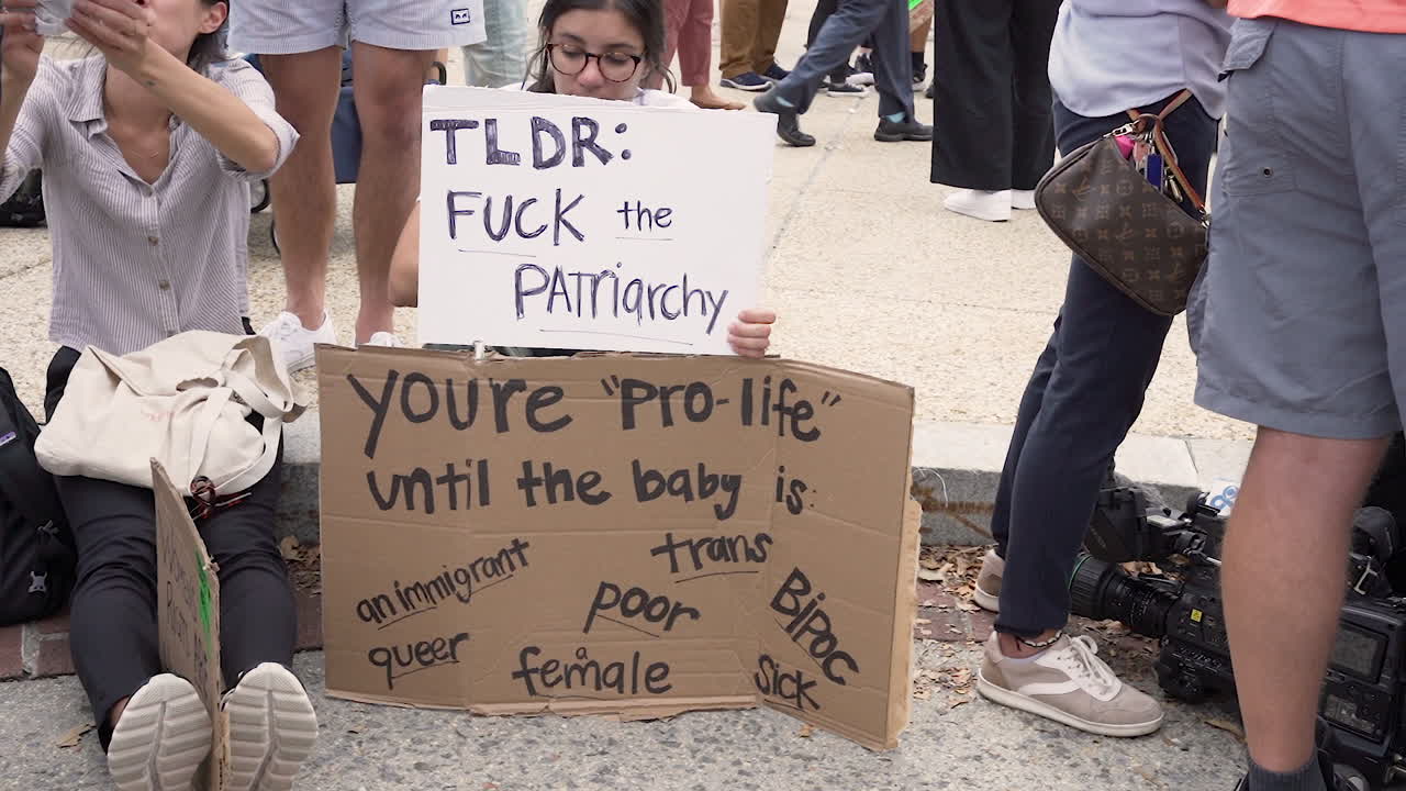 Abortion activist holds sign slow motion.
