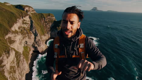 man hiking on a cliffside with ocean view
