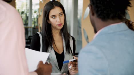 geconcentreerde collega ' s die papieren vasthouden en iets bespreken