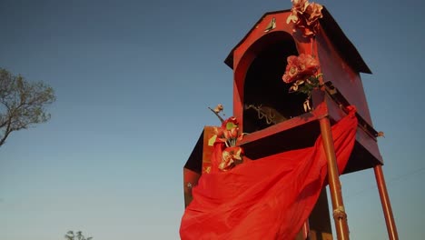 small red religious shrine in a field