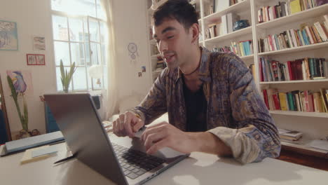 young man video calling on laptop at home