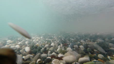 the surf waves move the pebble along the bottom an underwater video element power concept slow motio