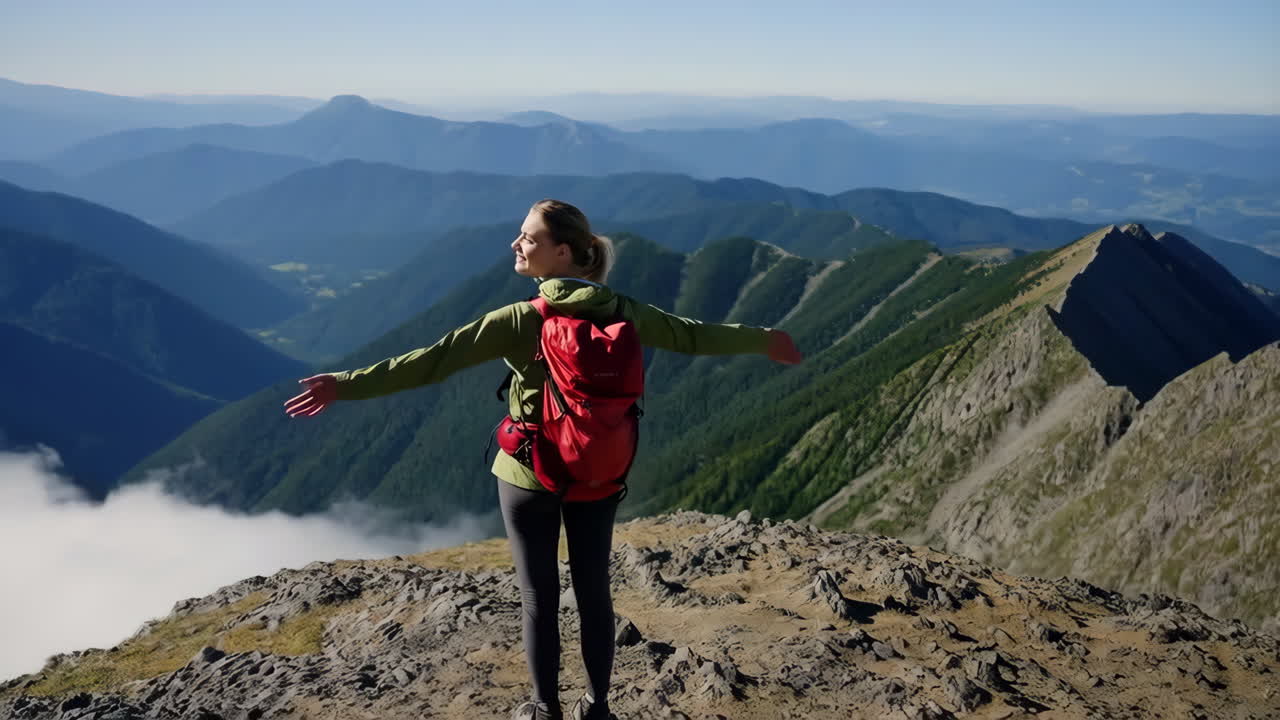 Woman celebrating triumph on a scenic mountain peak