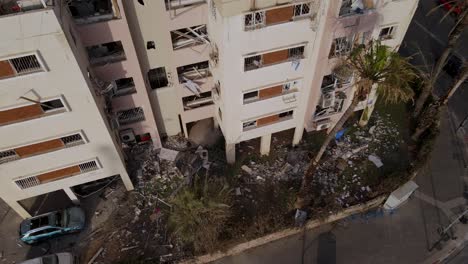 aerial top-down view showing debris and damaged facade of a building in tel aviv after a missile strike