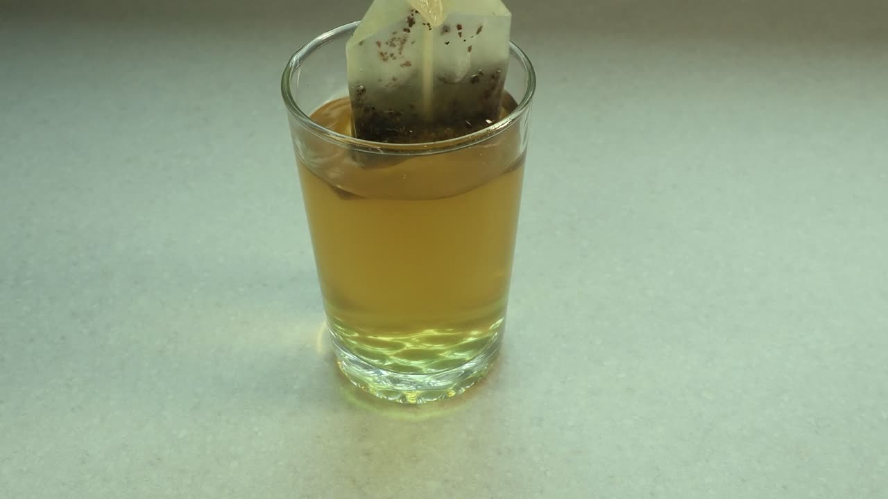 Preparare il tè caldo con una bustina di tè agitata nell'acqua.