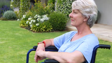 Thoughtful-senior-woman-sitting-in-wheelchair