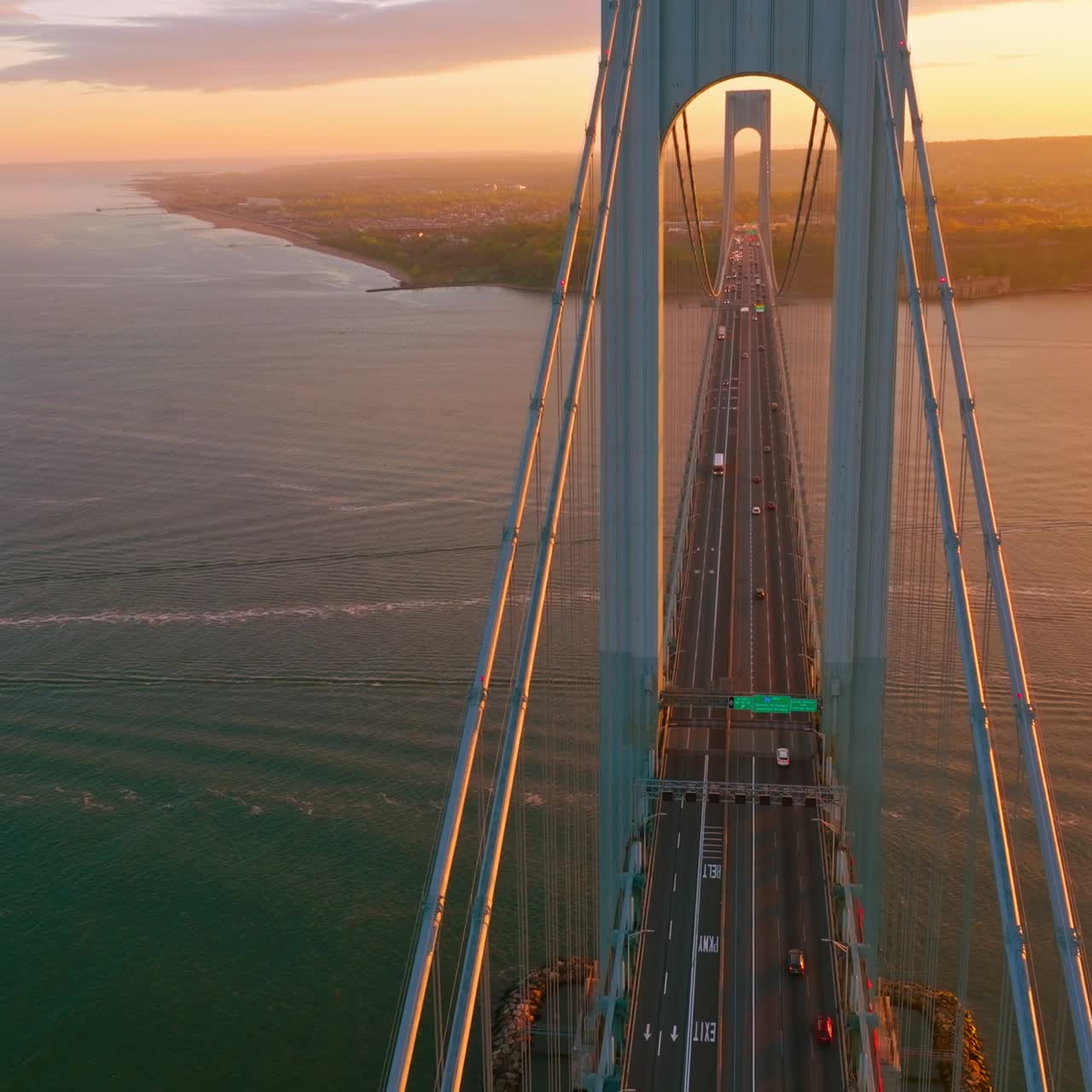 Beautiful bridge with motorways for transport. Top view. Huge structure over the river in the rays of setting sun