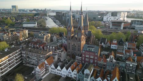 drone flies past posthoornkerk church bell towers in amsterdam, netherlands