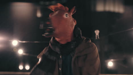 funny man wearing horse mask dancing in rain on rooftop having fun performing silly dance moves celebrating weekend