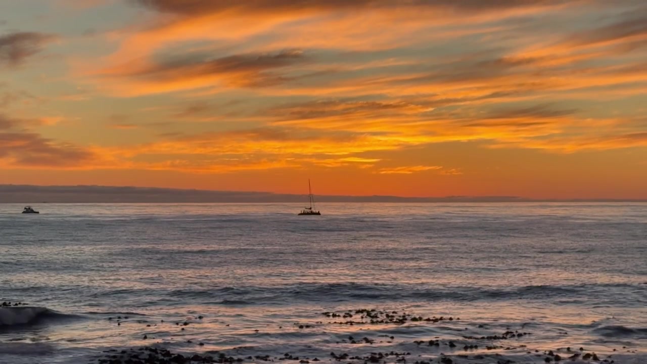 Un atardecer sobre el Océano Atlántico con barcos a lo lejos