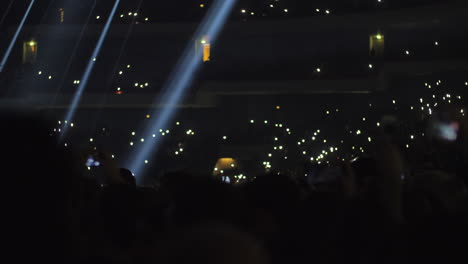 überfüllte konzertsaal-musikfans schwenken die lichter zur musik