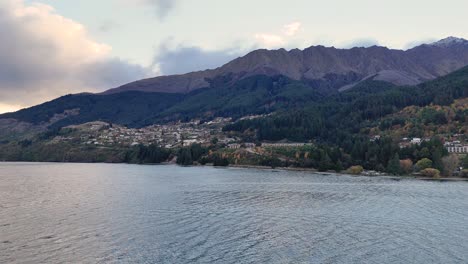 A tranquil view of Lake Wakatipu with surrounding mountains under soft, natural lighting. Captured in Queenstown, New Zealand