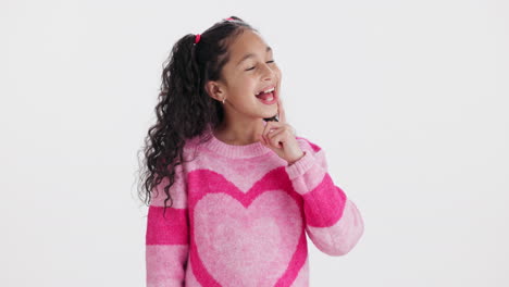 girl in pink heart sweater pointing and thinking