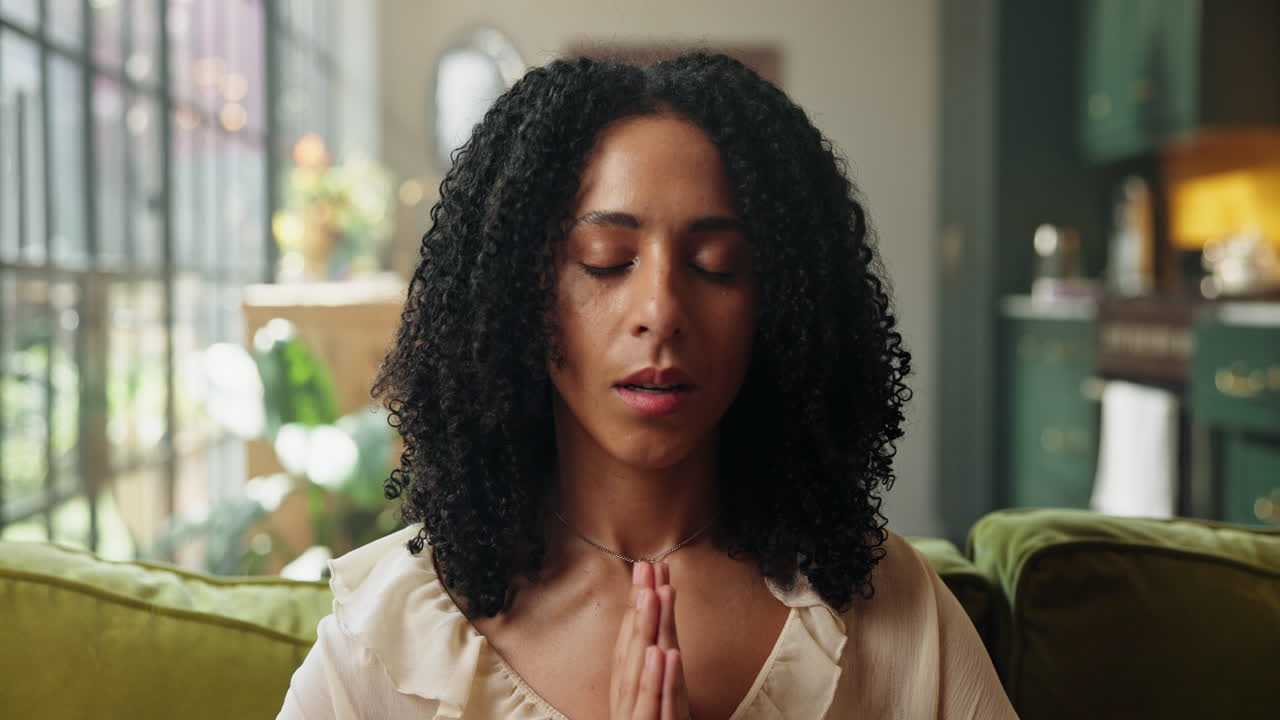 Calm Woman Meditating with Prayer Hands at Home