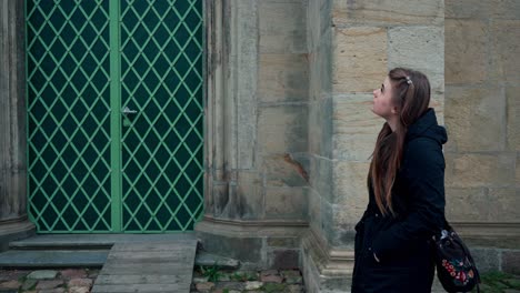 Chica-Solitaria-Y-Triste-Con-El-Pelo-Largo-Y-Una-Chaqueta-Caminando-Por-Las-Paredes-De-Una-Antigua-Iglesia