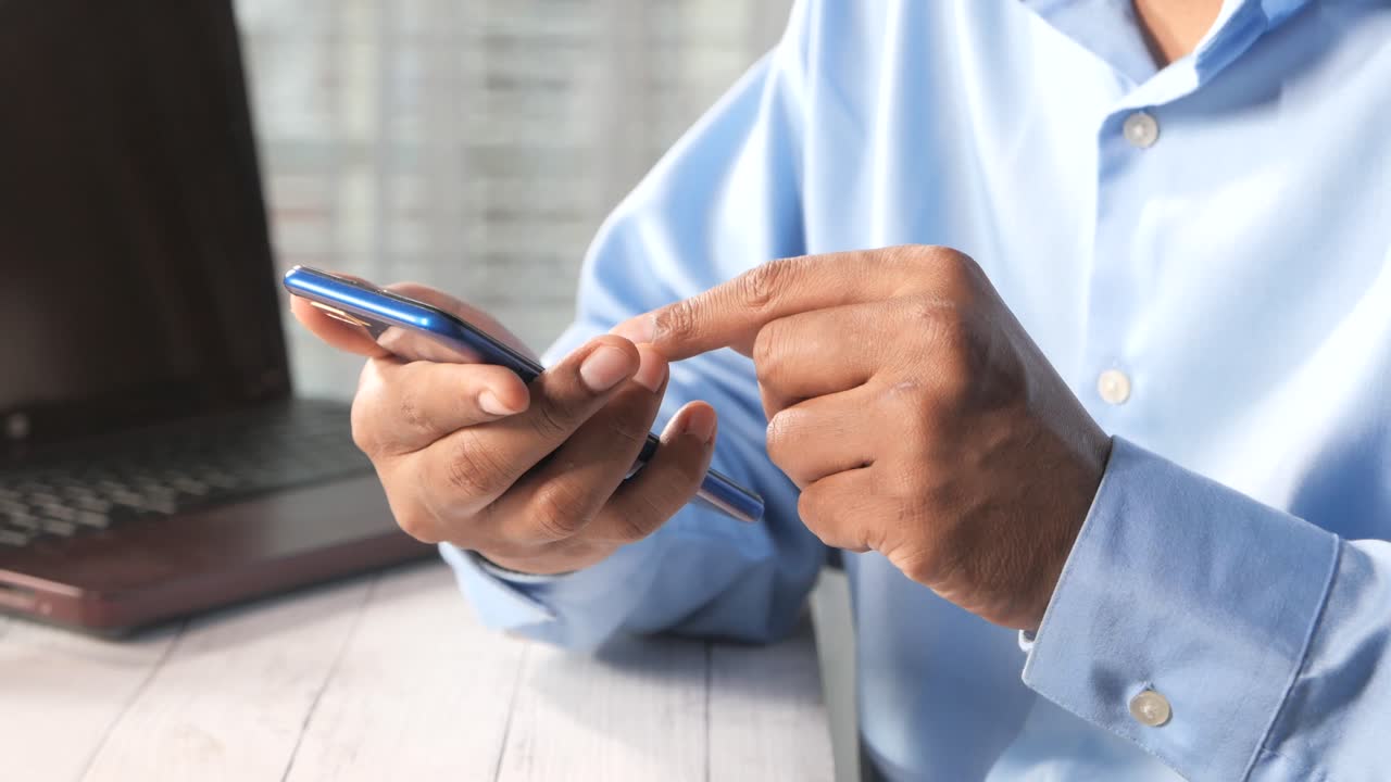 hombre usando teléfono inteligente en el escritorio