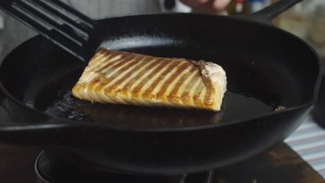 chef cooking salmon slice on frying pan