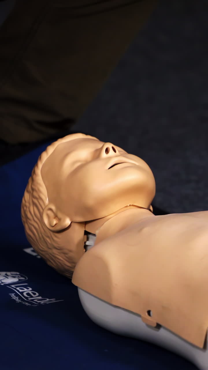 Practical course on a dummy's head. Medic showing medical exercise on a mannequin in the training center. Close-up. Vertical video