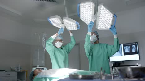 diverse surgeons with face masks preparing surgery in operating room in slow motion