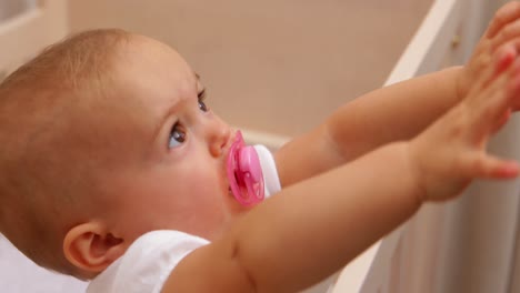 Cute-baby-girl-standing-up-in-her-cot