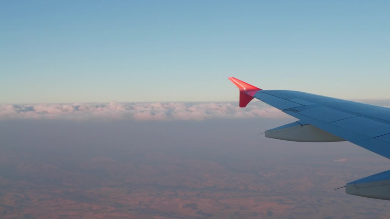 4K sakte film-opptak fra et flyvindu som viser flyvingen over et skylag og landskapet badet i varmt solnedgangslys nær Denizli i Tyrkia