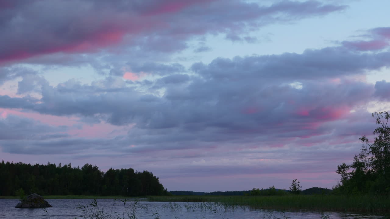 lapso de tiempo de coloridas nubes en movimiento sobre un lago por hora dorada