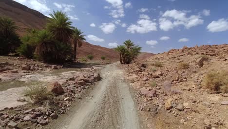 Punto-De-Vista-De-Un-Conductor-Que-Cruza-Un-Oasis-En-Las-Montañas-Del-Alto-Atlas-De-Marruecos