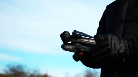 person with leather gloves remove drone gimbal protection and unfold device