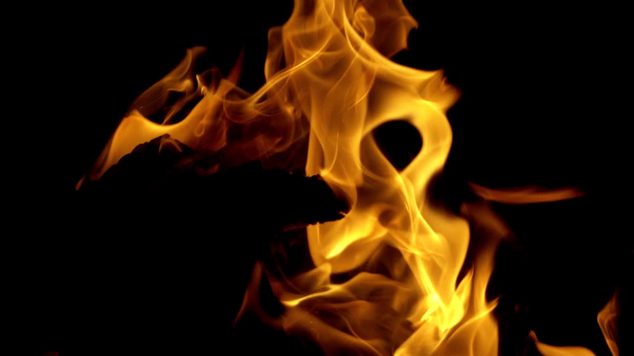 A fire burns in a fireplace. Burning fire at night. Burning Wood. Slow motion fire.