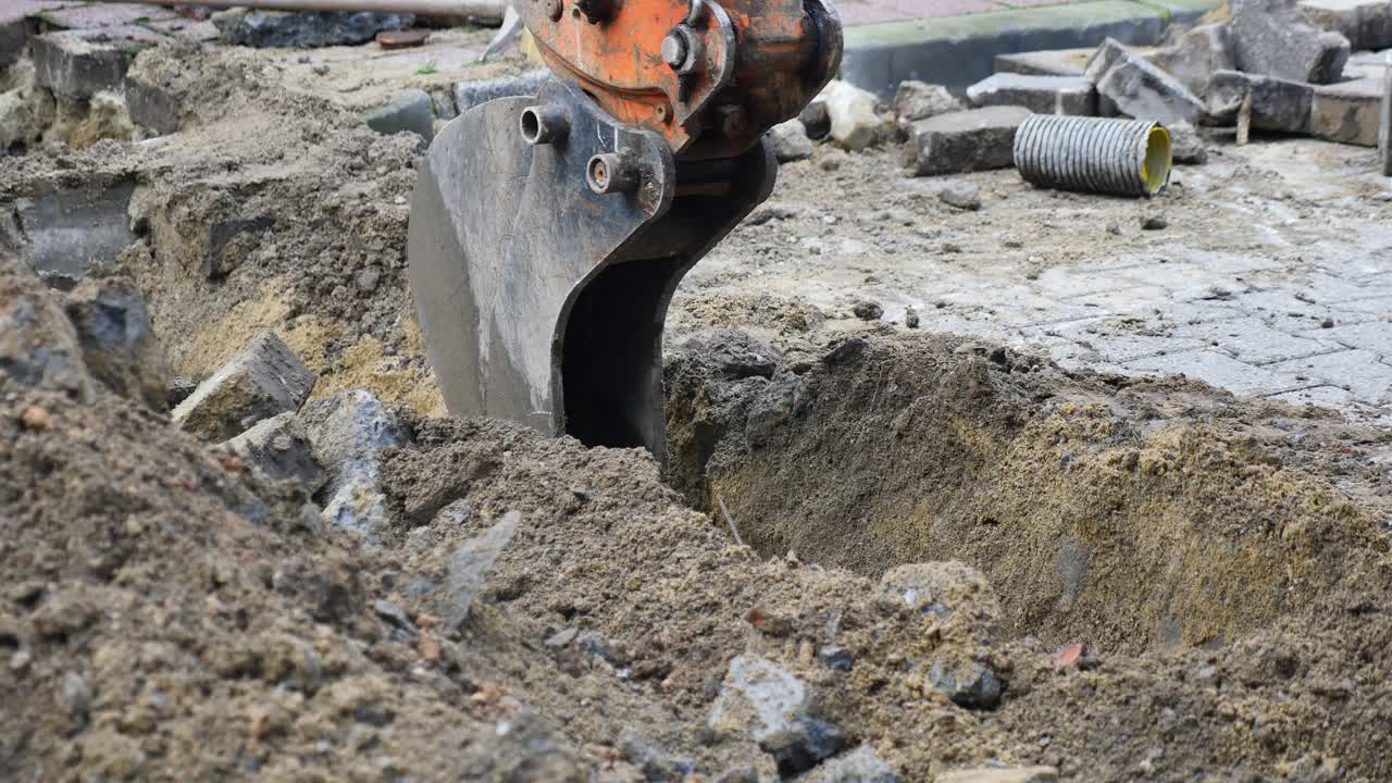 Escavatore che scava una trincea in un cantiere edile