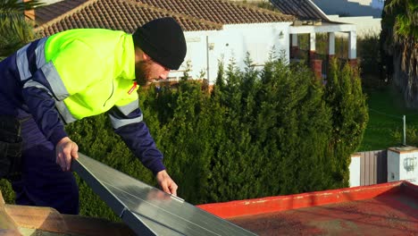 technician man installing solar panels over bricked roof in village