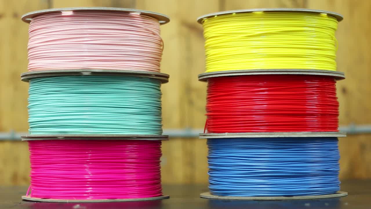 dos pilas de filamento de impresora 3d se sientan en un banco de trabajo