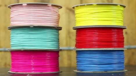 dos pilas de filamento de impresora 3d se sientan en un banco de trabajo