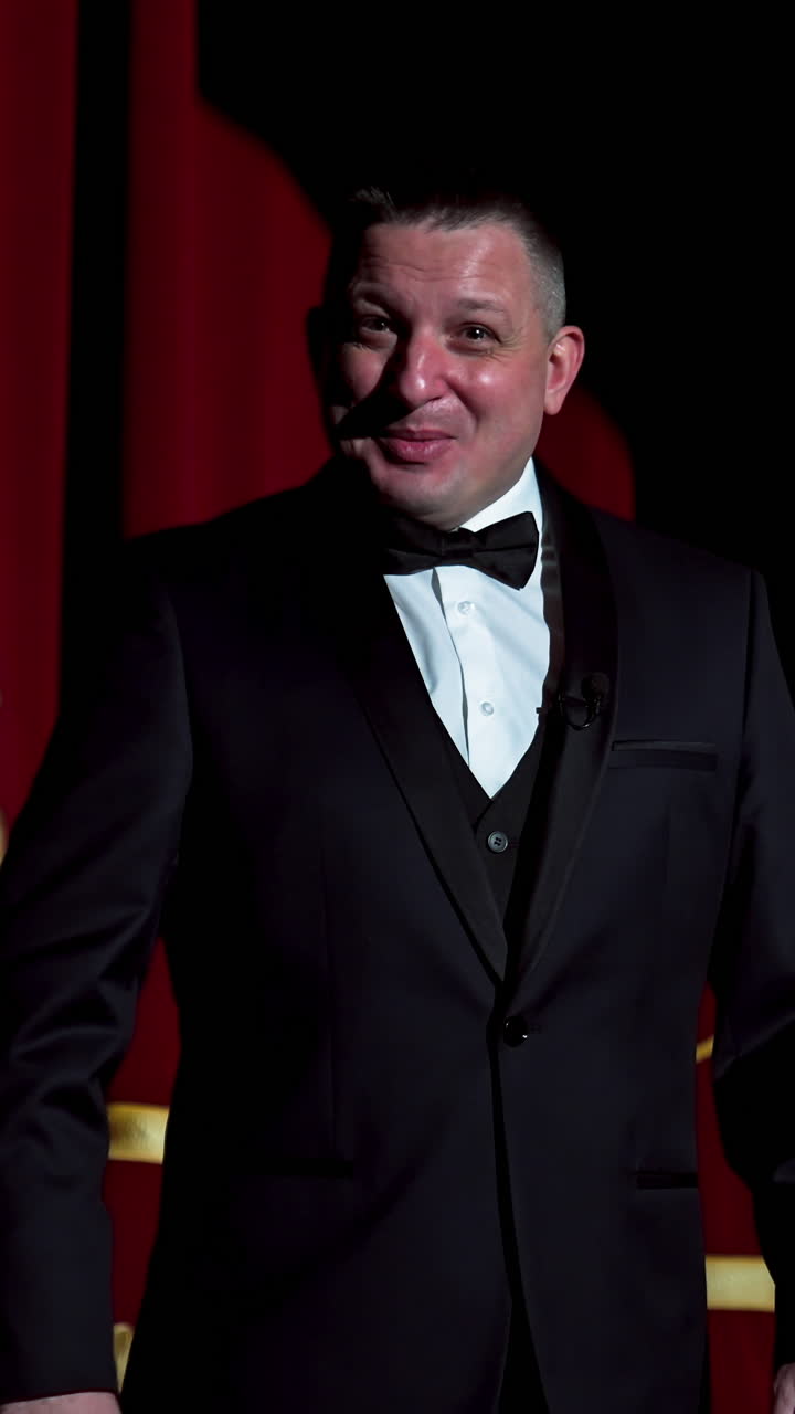 Actor on a stage. Adult man talks to the public in microphone or sings songs. Theater concept. Vertical video