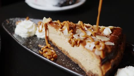 pouring caramel cream delicately on top of a piece of cake