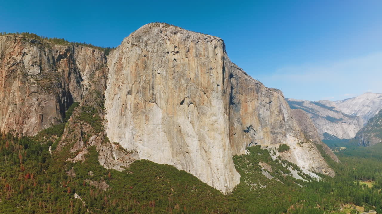 The Capitan Rock standing out among the rock formations in Yosemite national Park. Amazing mountains at the backdrop of clear azure sky.
