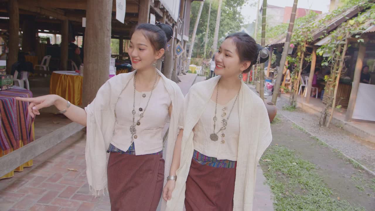 Two Teenage Girls In Thai Traditional Dress Walking Near Thai House, Slow Motion