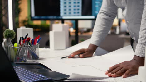 african american contractor examine architectural blueprints plans on table