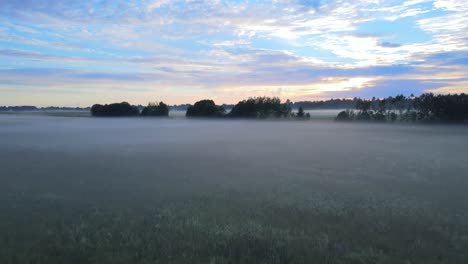 Drone-flying-fast-towards-the-sky,-fog-spreads-over-the-field-4K