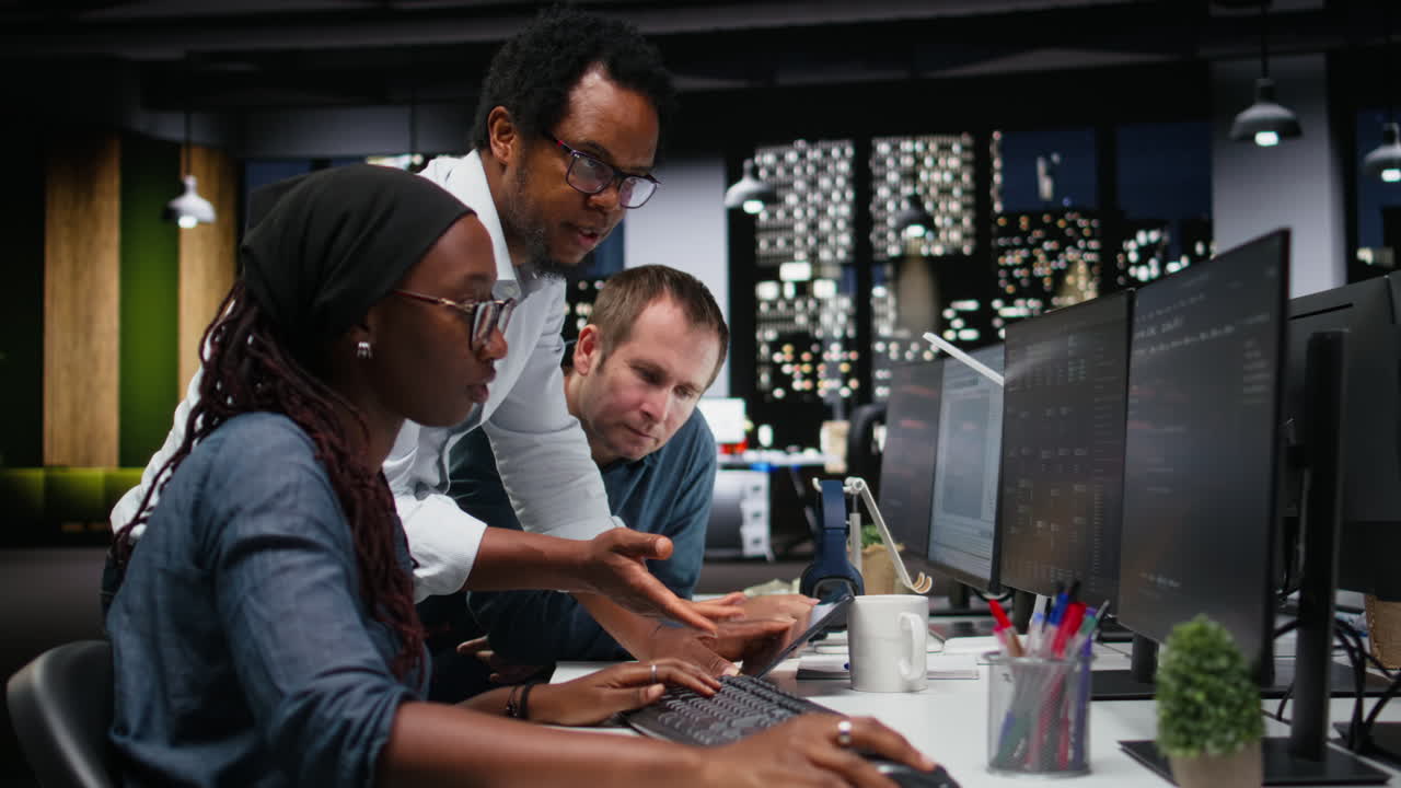 Diverse Team of Developers Collaborating on Software Project in Modern Office at Night