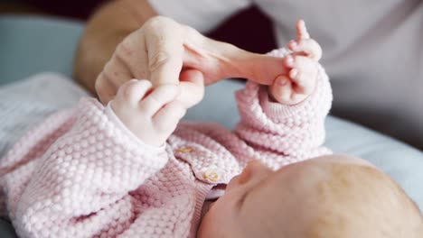 hand of dad soothing and playing with lying baby