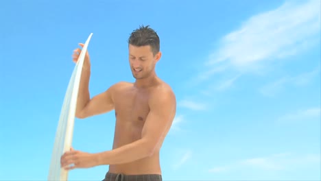 wellbuilt man getting out of the water after surfing