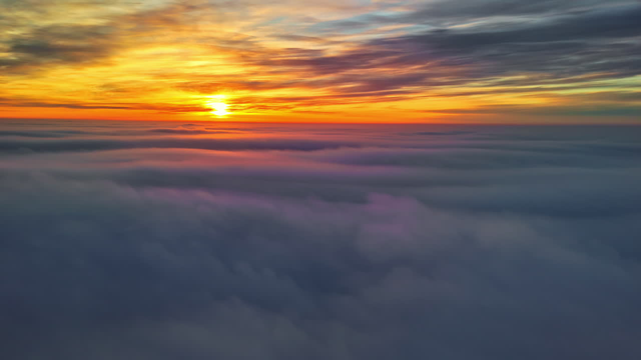 Plane trip above the clouds at sunset. Smooth view