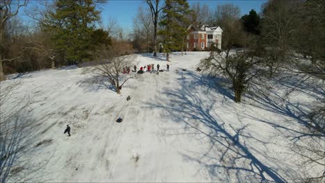 Un-Grupo-De-Personas-En-Trineo-De-Nieve-En-La-Ladera-De-Una-Colina---Vista-Aérea