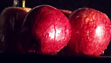 water splashing on red apples