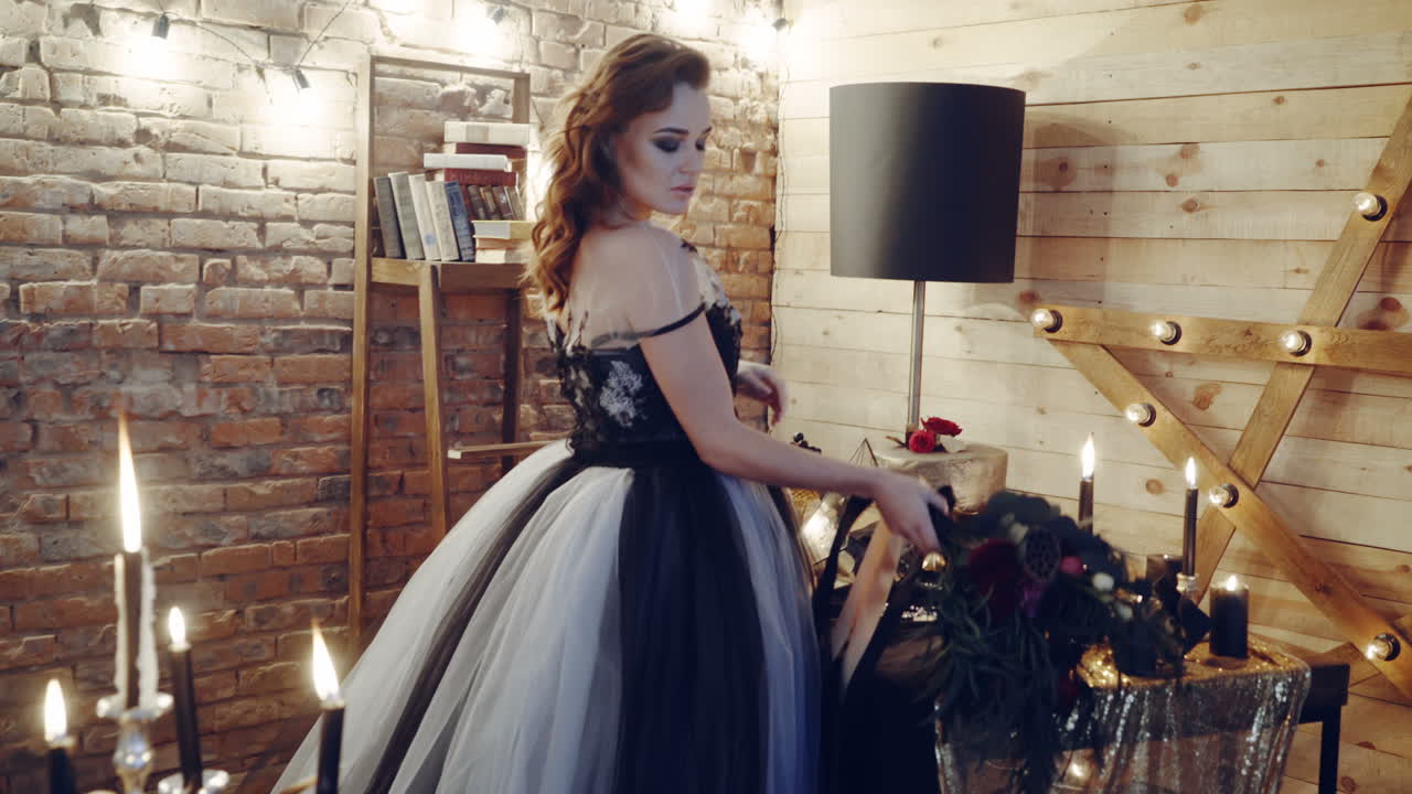 Witch at table. Portrait of woman dressed in witch style sitting by the table