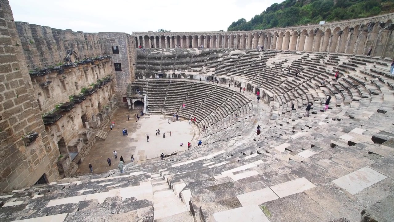 Türkiye'deki Antik Roma Aspendos Tiyatrosu'nu keşfeden turistler.