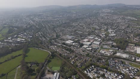 high aerial panorama of st austell spreading across gentle hills with dense housing, retail centres, light industry and surrounding patchwork countryside