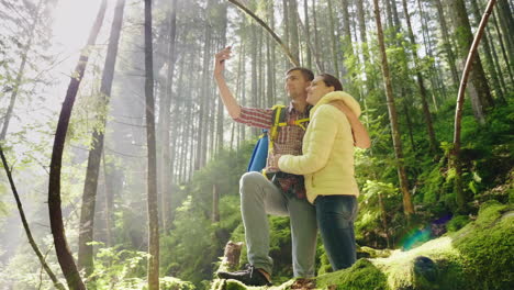 A-Couple-In-Love-Of-Travelers-With-Backpacks-Are-Photographed-In-The-Forest-The-Rays-Of-The-Morning